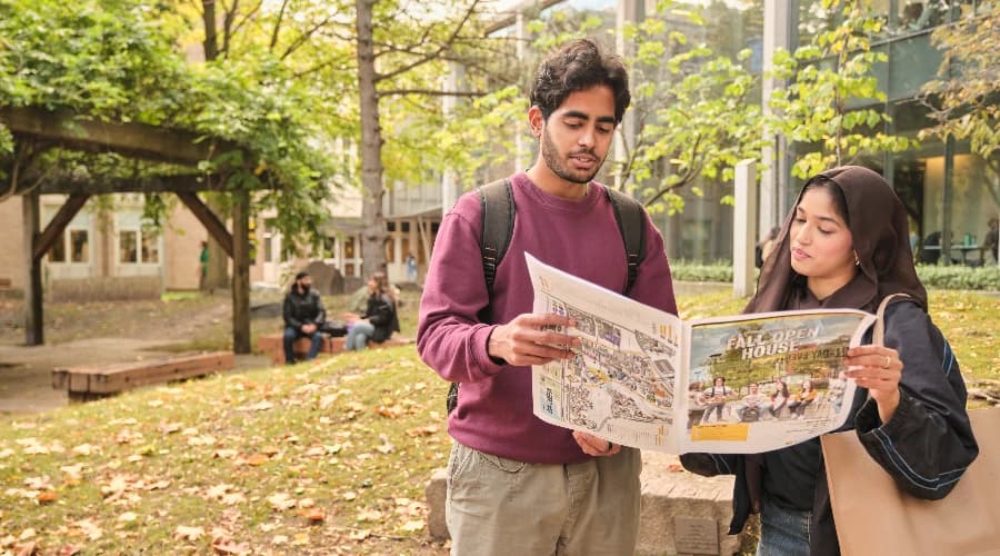 Two students look at a campus map outside at Waterloo